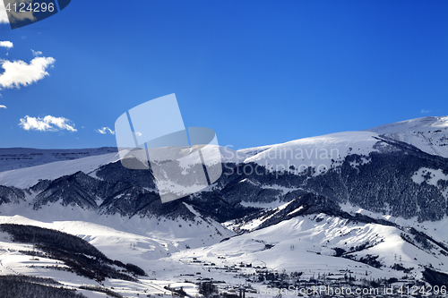 Image of Winter snow mountains and village at sun morning