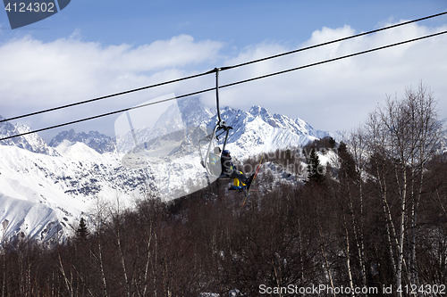 Image of Father and daughter on ski-lift at nice sun day