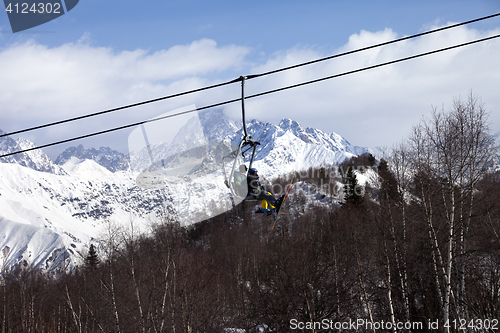 Image of Father and daughter on ski-lift at nice sun day