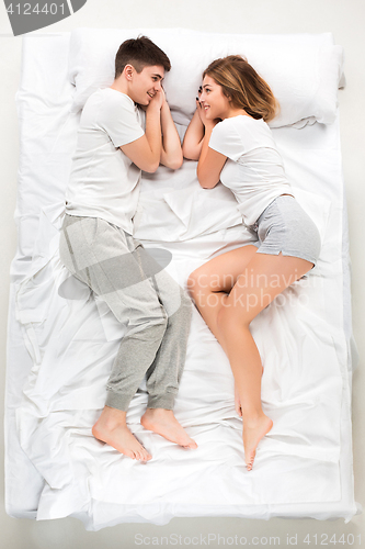 Image of The young lovely couple lying in a bed