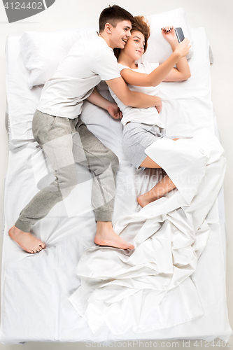 Image of The young lovely couple lying in a bed