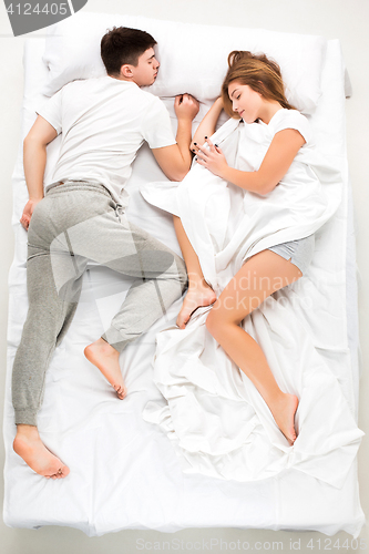 Image of The young lovely couple lying in a bed