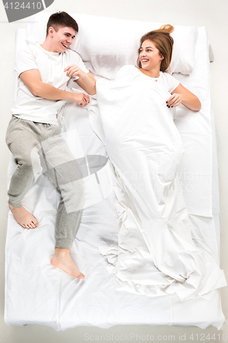 Image of The young lovely couple lying in a bed