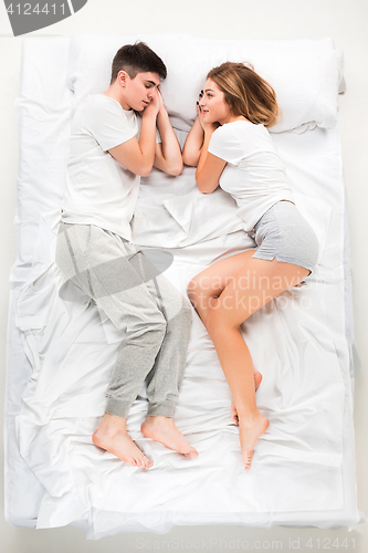 Image of The young lovely couple lying in a bed