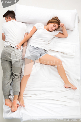 Image of The young lovely couple lying in a bed