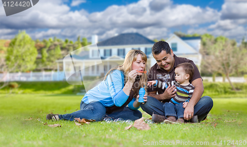 Image of Happy Mixed Race Ethnic Family Playing with Bubbles In Front Yar