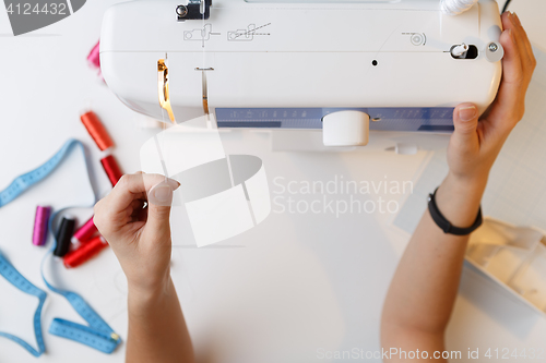 Image of Seamstress preparing work on sewing-machine