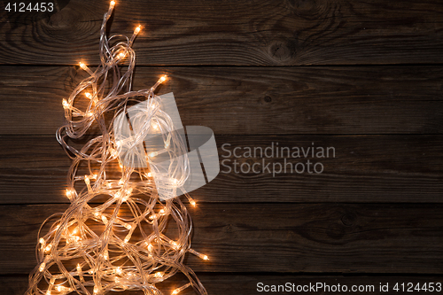 Image of Glowing festoon on brown background,