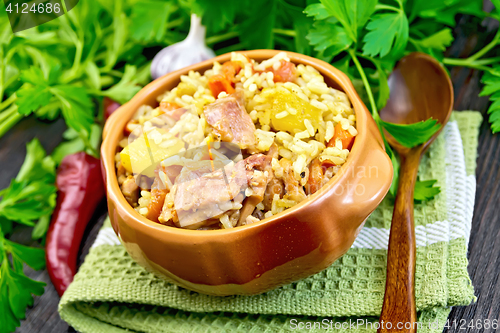 Image of Rice with chicken and zucchini in bowl on dark board