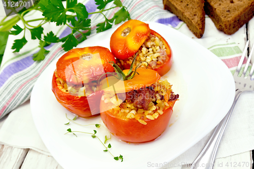 Image of Tomatoes stuffed with bulgur and meat in plate on board