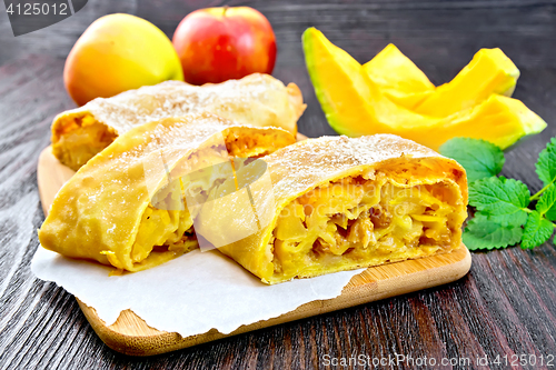 Image of Strudel pumpkin and apple on dark board