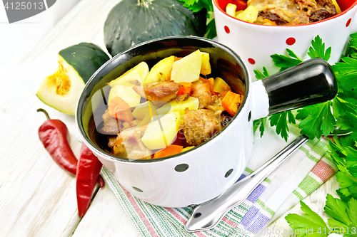 Image of Roast meat and vegetables in white pots on board