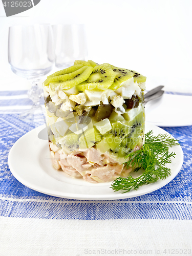 Image of Salad of chicken and kiwi on blue tablecloth