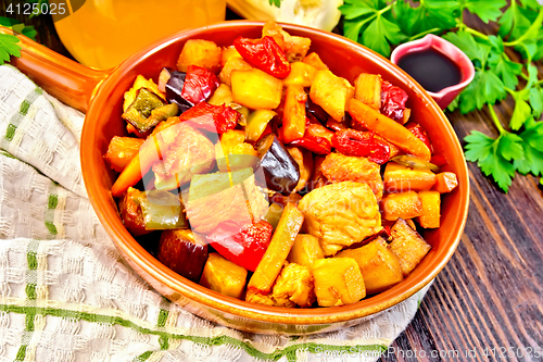 Image of Roast with vegetables and honey in pan on board