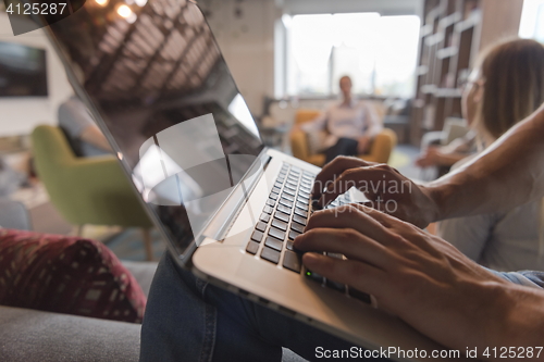 Image of close up of male hands while working on laptop