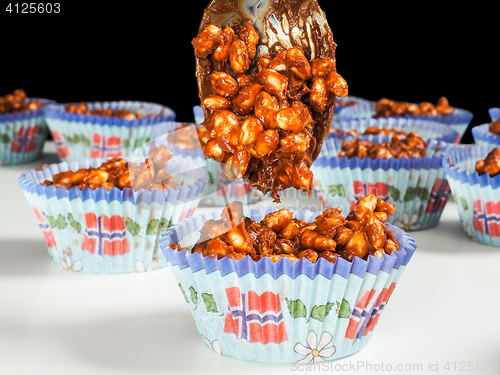 Image of Puffed rice chocolate cup cakes being filled, on white table tow