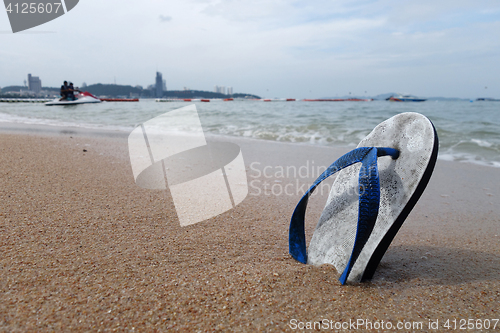 Image of Beach slippers on a sandy beach