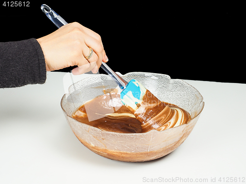 Image of Female person blending chocolate gently with Gogl-Mogl, in a gla