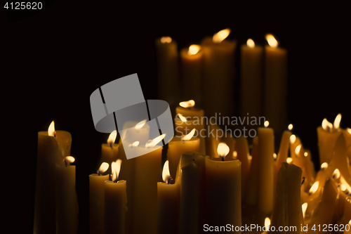 Image of Light many candles burning in the black background