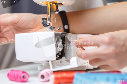 Image of Seamstress starts tailoring on sewing-machine