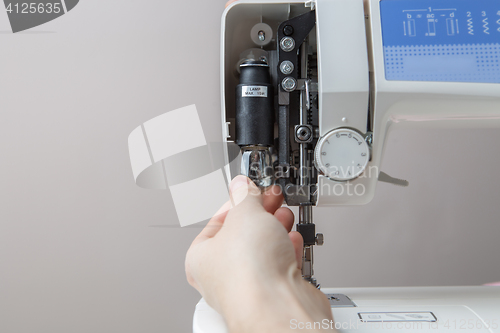 Image of Young man mending sewing machine