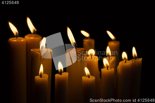 Image of Light many candles burning in the black background