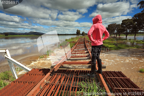 Image of Floodwaters run under buckled train tracks