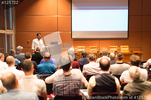 Image of Business speaker giving a talk in conference hall.