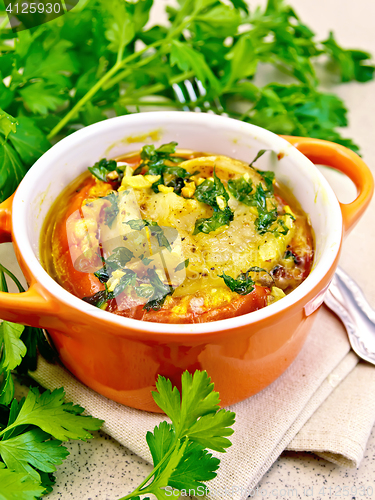 Image of Fish baked with tomato in red pot on stone table