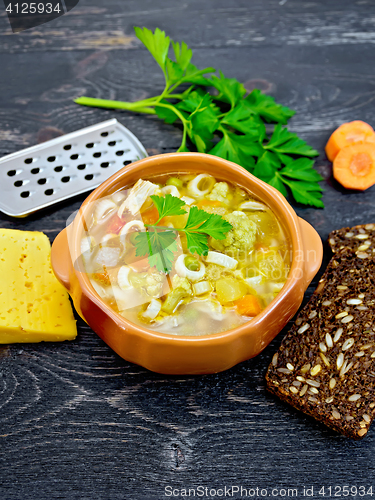 Image of Soup Minestrone in clay bowl on black board