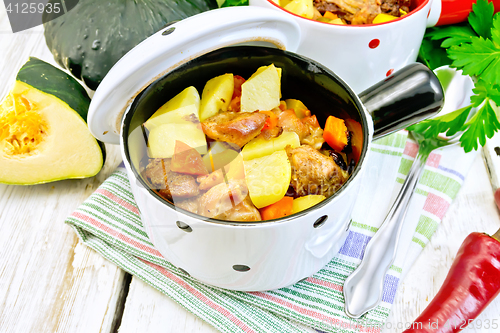 Image of Roast meat and vegetables in white pots on towel