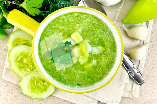 Image of Soup cucumber in yellow bowl on granite table top