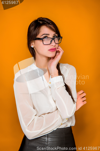 Image of The serious frustrated young beautiful business woman on orange background