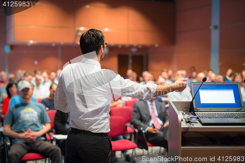 Image of Public speaker giving talk at Business Event.