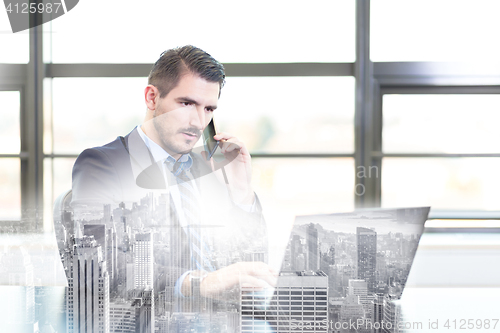 Image of Businessman in office working on laptop computer.