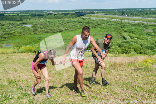 Image of Man helps the girl to rise on hill. Tyumen