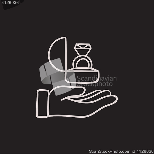 Image of Hand holding gift box with ring sketch icon.