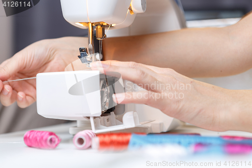 Image of Girl starts tailoring on sewing-machine