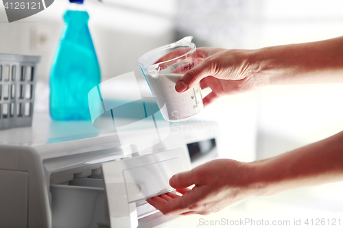 Image of hands of woman that fills detergent