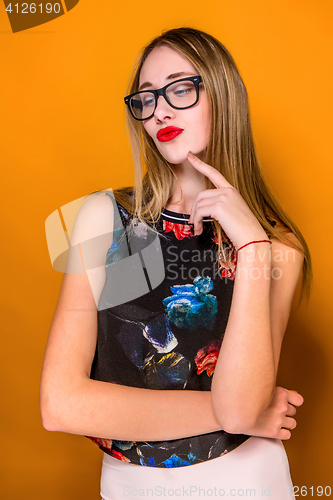 Image of The serious frustrated young beautiful business woman on orange background