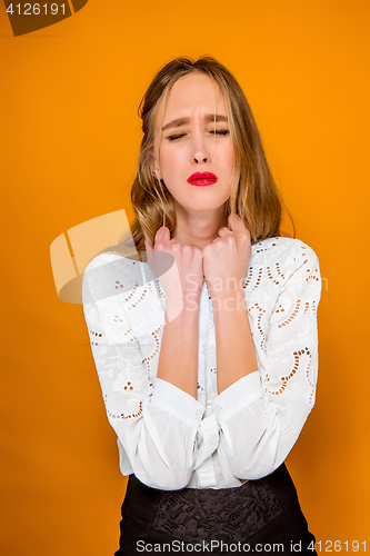 Image of The serious frustrated young beautiful business woman on orange background