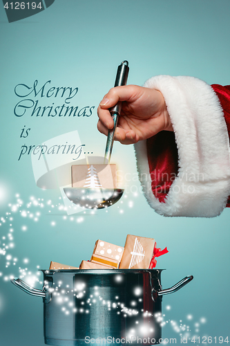 Image of The Santa hand holding a ladle or kitchen spoon