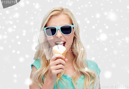 Image of happy young woman in sunglasses eating ice cream