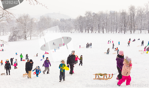 Image of Winter fun, snow, family sledding at winter time.