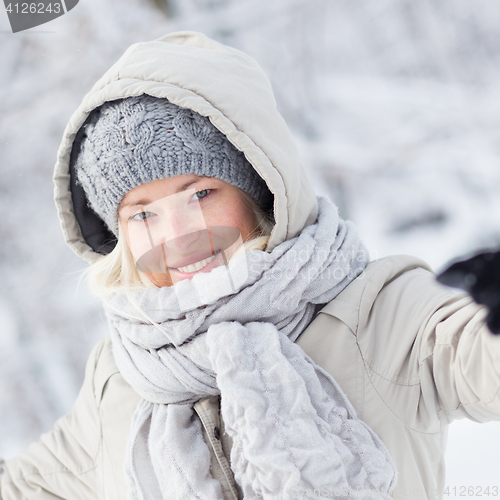 Image of Girl  playing with snow in winter.