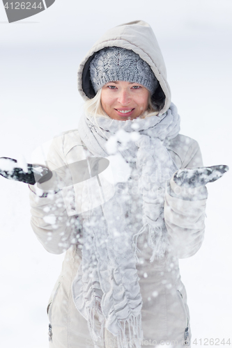 Image of Girl  playing with snow in winter.