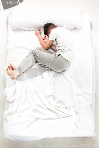 Image of The young man lying in a bed