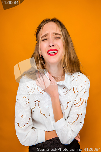 Image of The serious frustrated young beautiful business woman on orange background