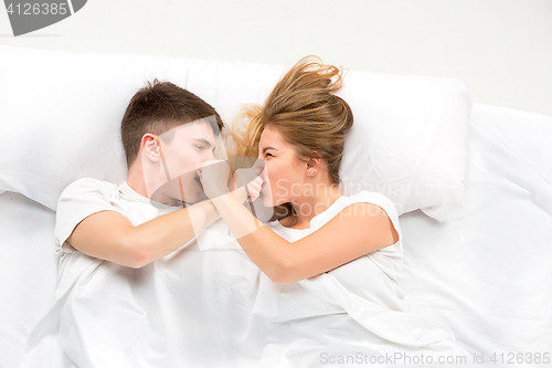 Image of The young lovely couple lying in a bed