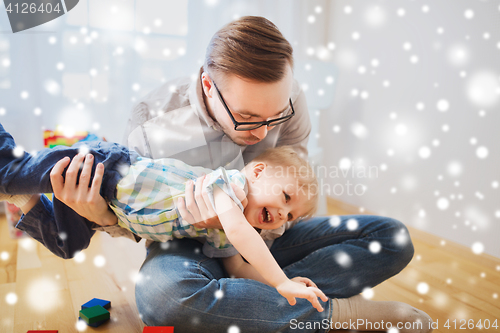 Image of father with son playing and having fun at home